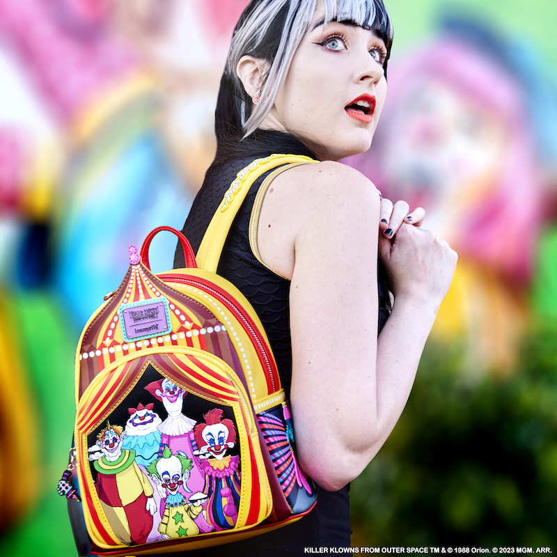 Woman wearing the Killer Klowns from Outer Space Mini Backpack against a blurry, colorful wall